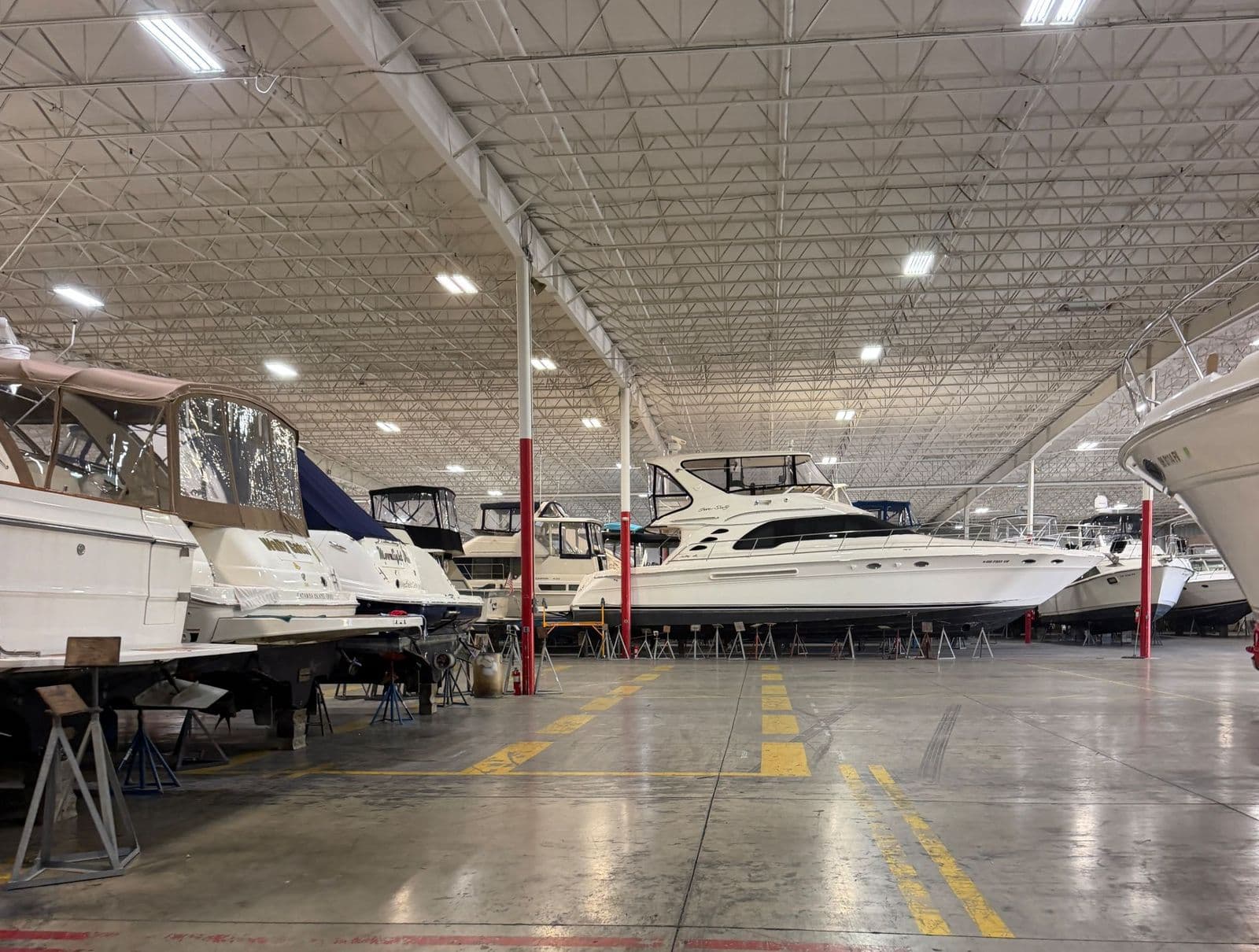 Boats stored on jack stands inside a heated winter storage building