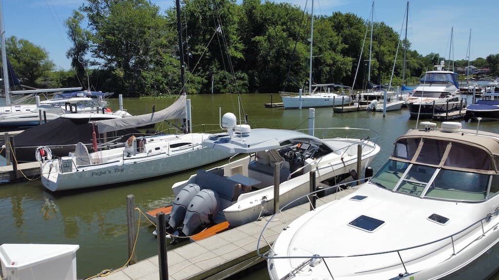 Sailboats, a center console, and an express cruiser docked together at a Lake Erie marina, illustrating the range of boat sizes Cleveland buyers consider