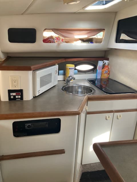 1994 Bayliner 3055 galley with microwave, sink, and electric stove top