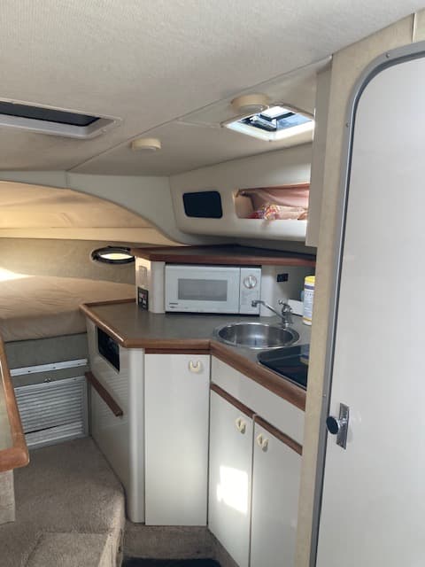 1994 Bayliner 3055 galley with microwave and stereo, V-berth storage visible