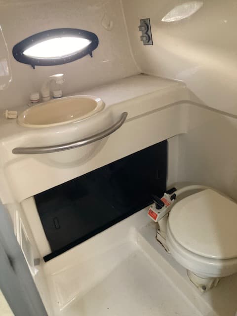 1994 Bayliner 3055 enclosed head with sink, flush toilet, and portlight